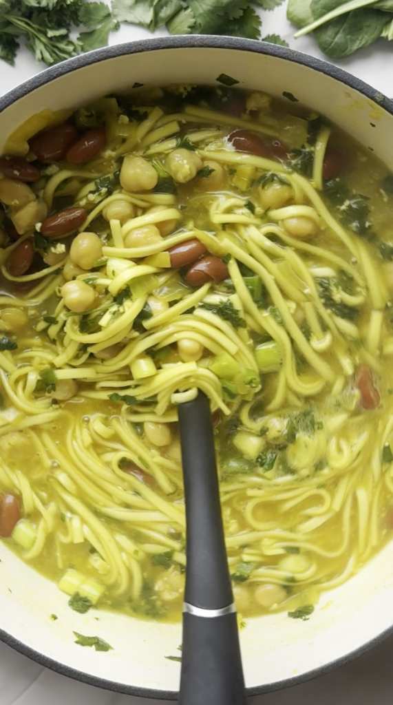 a ladle of Aush/Ash Reshteh. noodles, beans, amazing seasonings and sauces